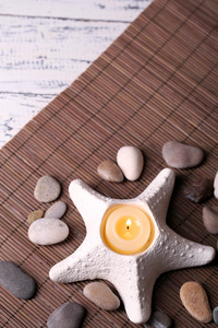 用 spa 石头组成，七支蜡烛的竹垫背景