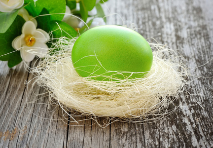绿色的复活节彩蛋是在旧的木制背景上巢里