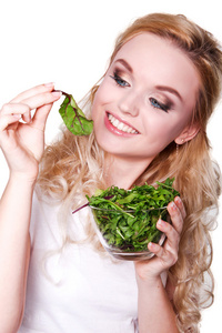 年轻漂亮的女人吃绿色新鲜的沙拉的肖像
