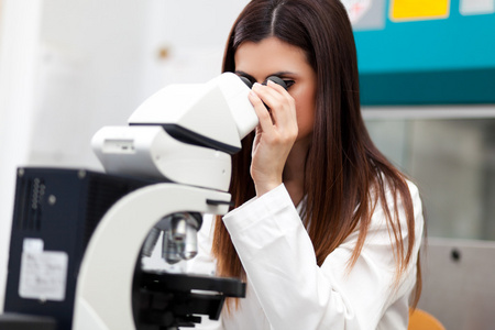 在实验室里用显微镜的女人