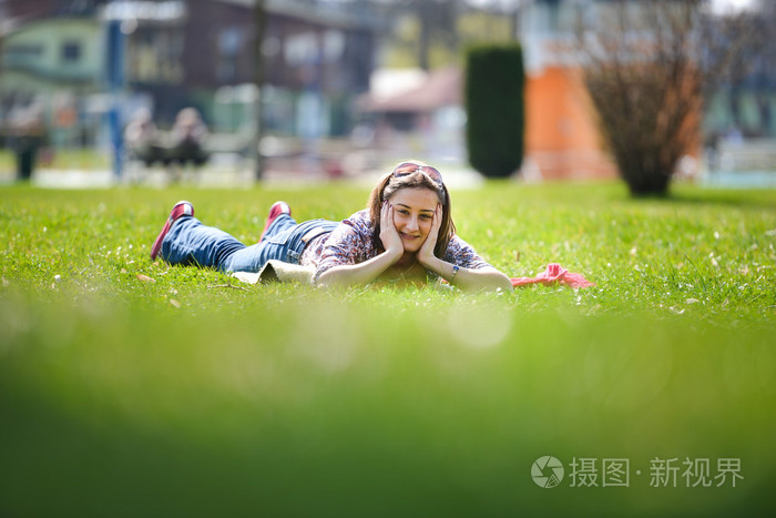 躺在草地上,在夏天的年轻女人.到户外放松照片-正版1