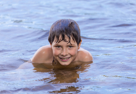 小男孩在湖中游泳