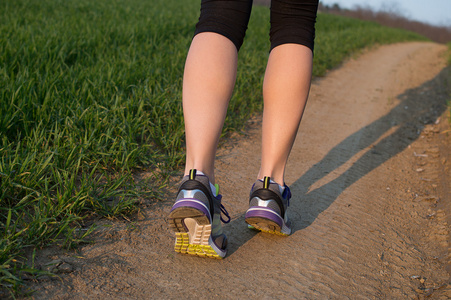 运动员脚上道路特写鞋上运行。女人健身