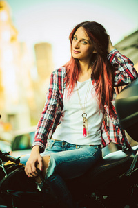 骑摩托车的年轻美丽的女人