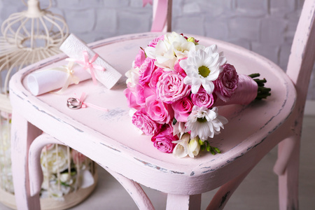 美丽的婚纱静物与花束在木椅上