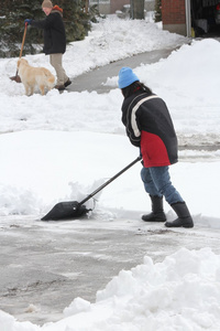 夫人从车道上的铲雪