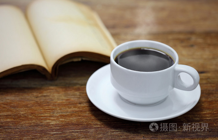 杯咖啡,在一张小木桌上的书