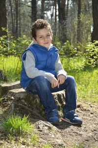绿眼的男孩坐在树林里