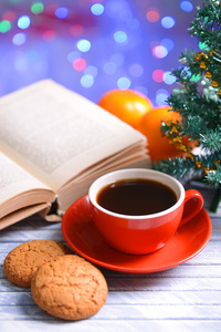本书带杯咖啡和圣诞装饰品上明亮的背景表格的组成