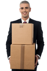 企业的男人微笑着，拿着箱叠
