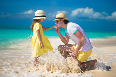 幸福的父亲带着他的小女儿享受海滩度假