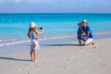 照片制作电话她家人在海滩上的小女孩