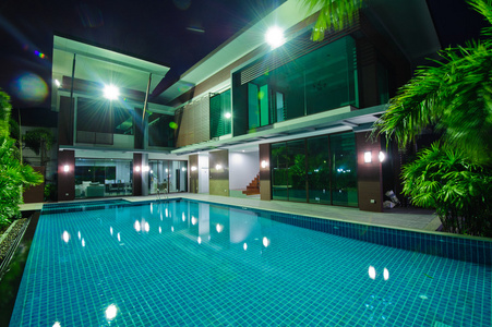 现代的房子，有室外游泳池，在夜间