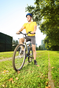 男子站在一辆自行车在公园里