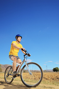 男性骑自行车在阳光灿烂的日子