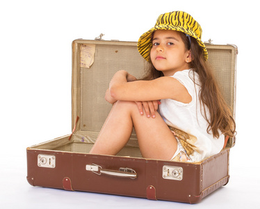 小女孩坐在一只手提箱