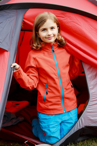 在帐篷里上露营的年轻女孩的夏天
