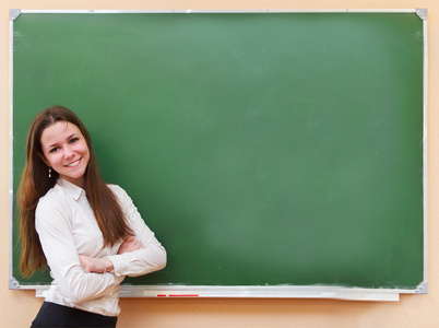 女学生站在教室里的黑板旁边