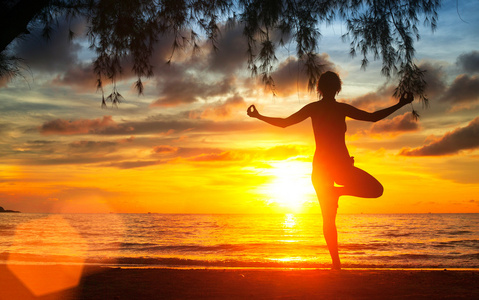 女人练瑜伽在海滩上
