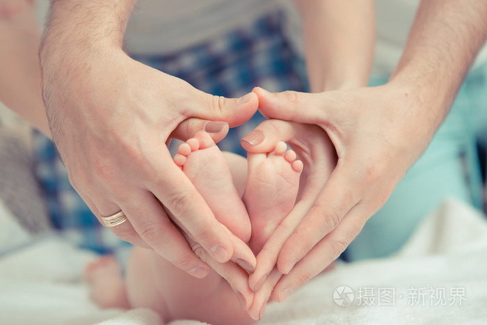 母亲和父亲举行的婴儿的脚