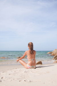 年轻女子在沙滩上打坐