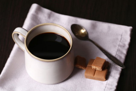 有热咖啡和甜甜的糖果，木桌背景上的杯子
