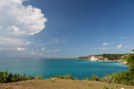 美丽的海滩，在那里人们正在冲浪在水中的视图。巴厘岛。balangan