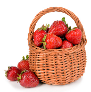 在孤立的白色衬底上的柳条篮子里的甜草莓成熟