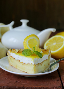 一块柠檬蛋糕塔装饰着新鲜柠檬和薄荷