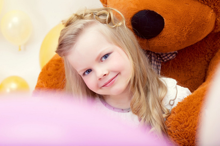 微笑和玩具熊的合影的蓝眼睛的女孩