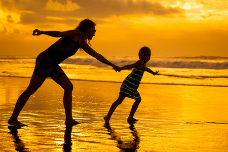 mor och dotter som spelar p stranden