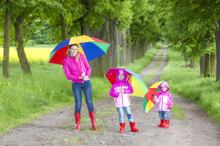 母亲和她的女儿带着伞在春巷