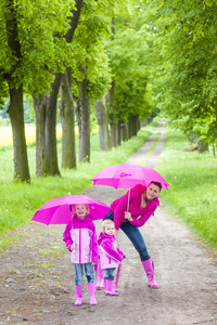 母亲和她的女儿带着伞在春巷