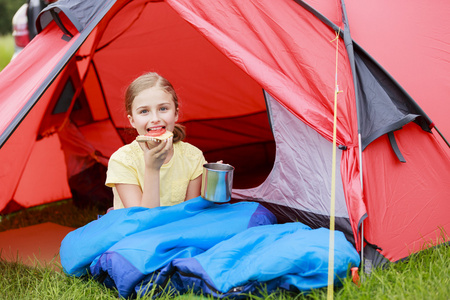 在帐篷里的年轻女孩在野营营地