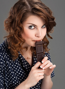 美丽的年轻女子吃巧克力