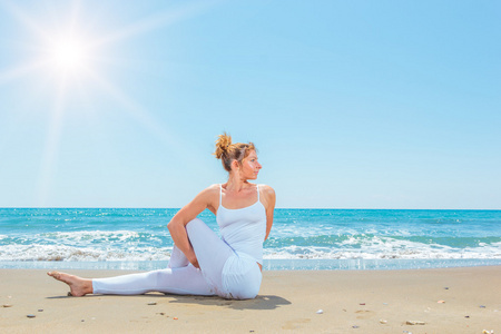 白种女人练瑜伽在海滩上