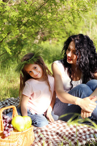 快乐妈妈和女儿。绿色公园野餐