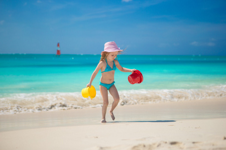 可爱的小女孩，在一个完美的热带海滩上玩沙子
