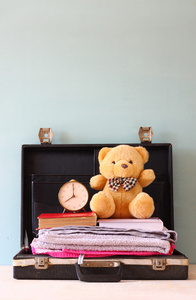 打开书毛巾泰迪熊与古董钟的案例。度假概念