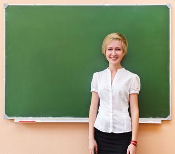 女学生站在教室里的黑板旁边