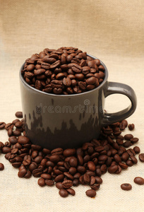 粗麻布上装满咖啡豆的咖啡杯