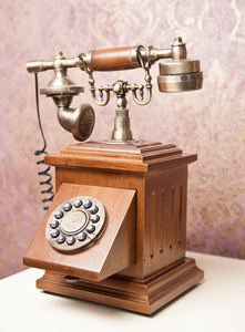 旧的木制手机。白色桌上的老式木制电话。复古电话