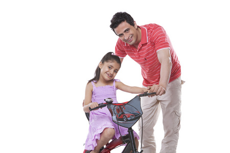 父亲协助女儿骑辆自行车