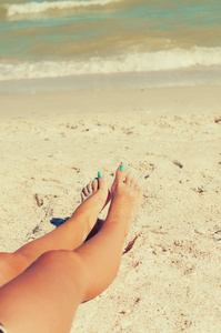 女孩双脚在海滩上的沙