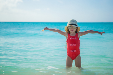 可爱的小女孩，在暑假期间的海滩上的帽子