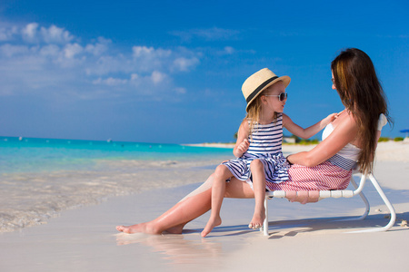 年轻的母亲和可爱的小女儿在地处热带的海滩