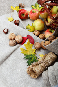 苹果和核桃亚麻画布上。秋天的主题