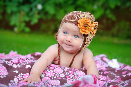 在户外爬行在棕色针织帽的可爱的小宝贝