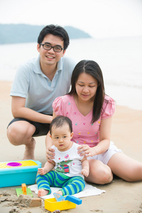 在沙滩上玩的亚洲家庭