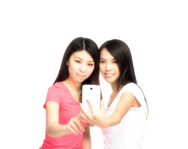 两个美丽的亚洲女孩微笑使拍照手机的 ph 值